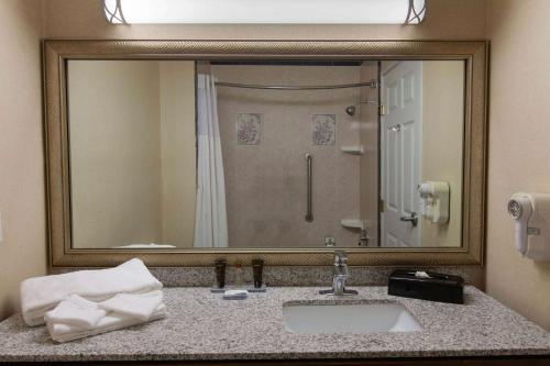 a bathroom with a sink and a large mirror at Wingate By Wyndham Houston / Willowbrook in Houston