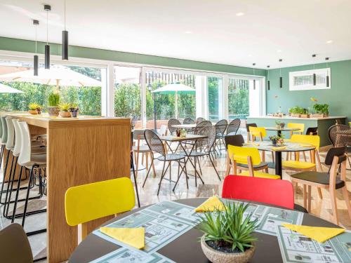 a dining room with tables and chairs and windows at Aparthotel Adagio Rome Vatican in Rome
