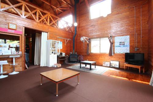 a room with a table and a wood wall at Gokase Campsite Camping and Guesthouse in Gokase