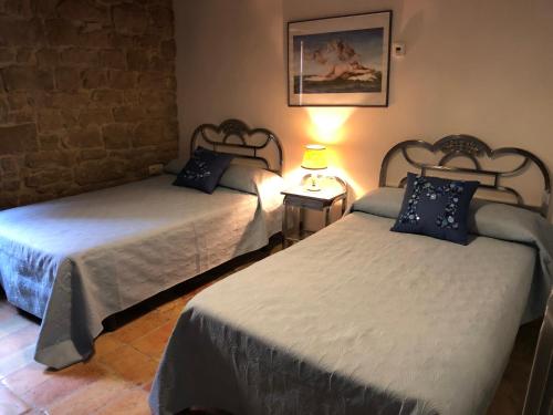 a bedroom with two beds and a lamp on a table at Solano de Moran in Murillo de Gállego