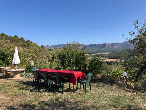 a table and chairs with a red table and a umbrella at Solano de Moran in Murillo de Gállego