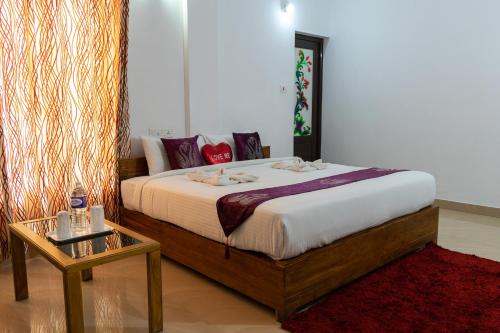 a bedroom with a large bed and a table at Pine Tree Munnar in Munnar