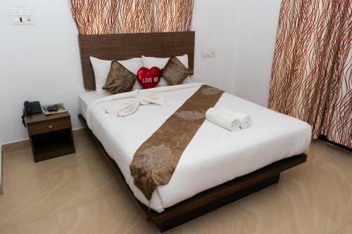 a bedroom with a large bed with white sheets and pillows at Pine Tree Munnar in Munnar