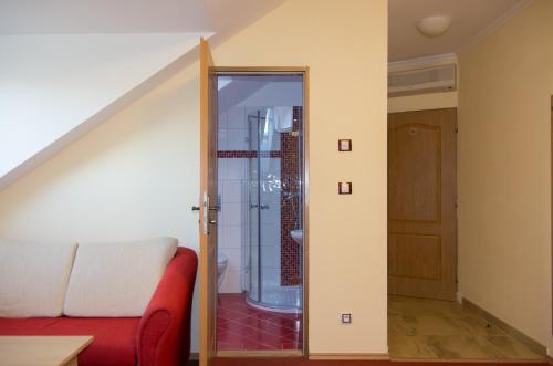 a living room with a red couch and a glass door at Pension Kiwi in Mikulov