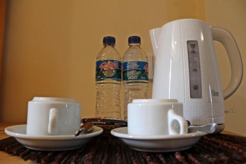 una mesa con dos tazas y dos botellas de agua en Exotic Komodo Hotel, en Labuan Bajo