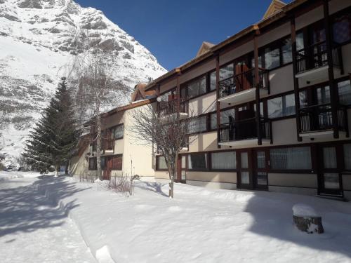 a building in the snow next to a mountain at Studio 4 personnes équipé wifi in Bessans