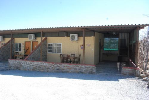 a house with a patio and a table in front of it at Oppi-Koppi Rest Camp in Kamanjab
