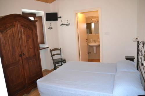 a bedroom with a bed and a bathroom with a sink at Agriturismo Antico Muro in Sassoferrato