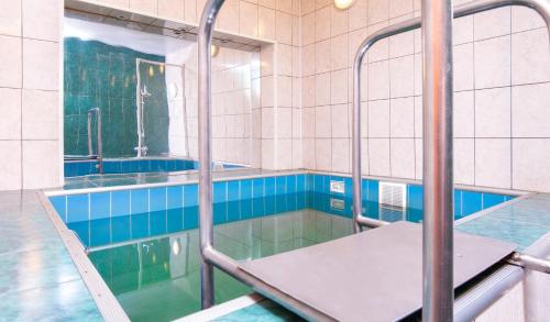 a swimming pool with a table in the water at Annushka Hotel in Saint Petersburg