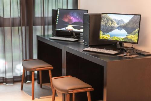 a desk with two computer monitors and two chairs at Orakai Daehakro Hotel, BW Signature Collection in Seoul