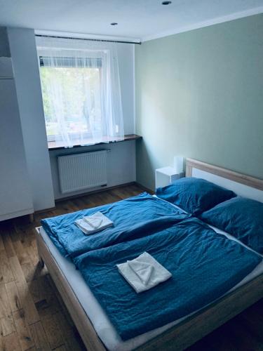 sypialnia z niebieskim łóżkiem i 2 ręcznikami w obiekcie Listopadowa43 - z garażem w Bielsku Białej