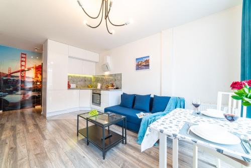 - un salon avec un canapé bleu et une table dans l'établissement Apartament Sobieskiego 2a Parking gratiss, à Bydgoszcz