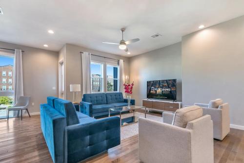 a living room with blue furniture and a flat screen tv at Modern 4BR Villas with Amenities in New Orleans