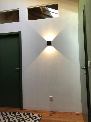 a room with a door and a light on the wall at la maison d'Obinat in Auzas