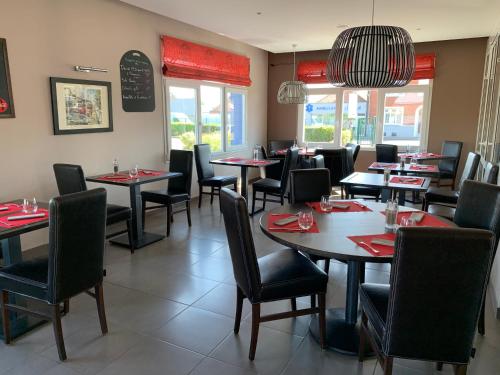 une salle à manger avec des tables et des chaises dans un restaurant dans l'établissement Le Logis De La Lys, à Aire-sur-la-Lys