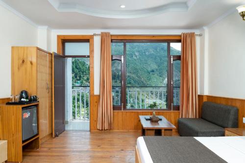 um quarto de hotel com uma cama, um sofá e uma janela em The Posh Hotel em McLeod Ganj