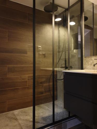uma casa de banho com um chuveiro com paredes de madeira e um lavatório em Apartament Kniaziewicza em Breslávia