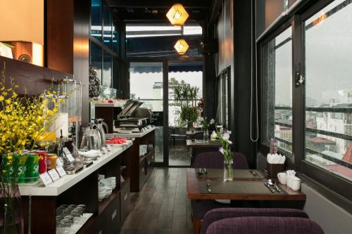 a restaurant with tables and chairs and windows at Hanoi Fiesta Hotel & Spa in Hanoi
