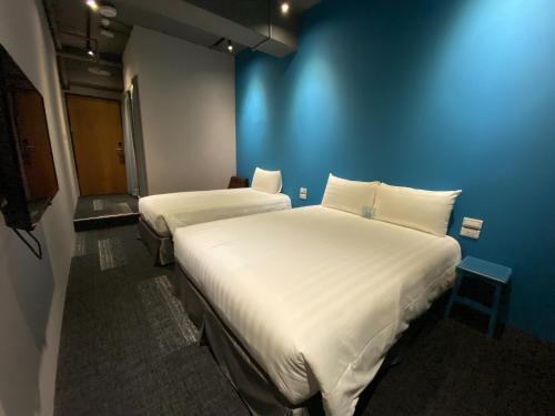 
a hotel room with two beds and two lamps at Cho Hotel 3 in Taipei
