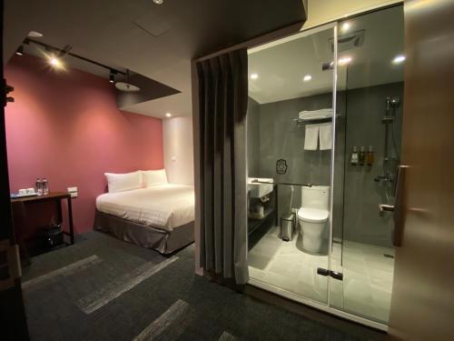 a hotel room with a bed and a glass shower at Cho Hotel 3 in Taipei