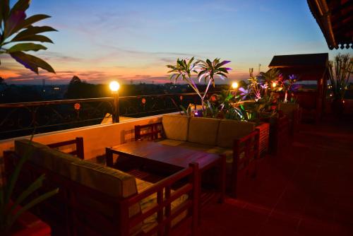a table and chairs on a balcony with a sunset at The Suite By Royal Crown Hotel in Siem Reap