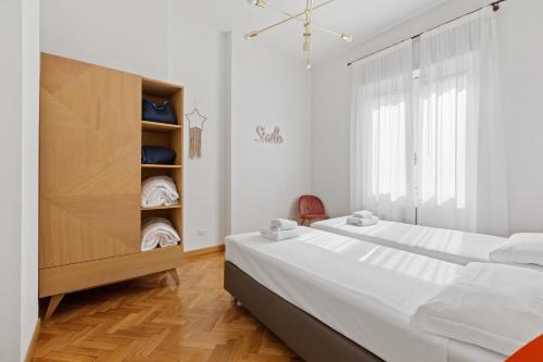 um quarto branco com uma cama grande e um closet em Roomy Apartment Duomo & San Babila em Milão