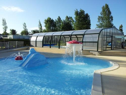 a water slide in a pool in a park at Camping La Berquerie in Le Mesnil-Réaume