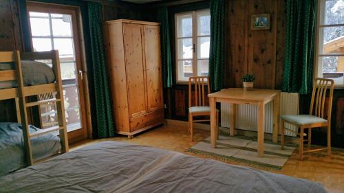 a bedroom with a bed and a table and chairs at Villa Zeppelin - App Smaragd in Bramberg am Wildkogel