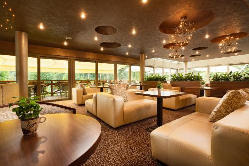 a lobby with couches and tables and windows at Hotel Termál in Vyhne