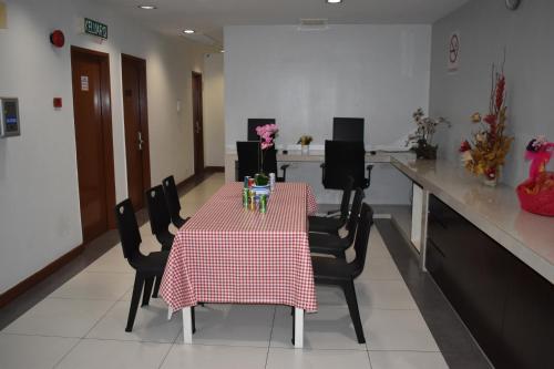 a table with chairs and a red and white table cloth at WL HOTEL in Kampung Baharu Sungai Buluh