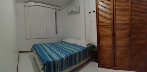 um pequeno quarto com uma cama e um closet em Lindo apartamento dúplex em Salvador
