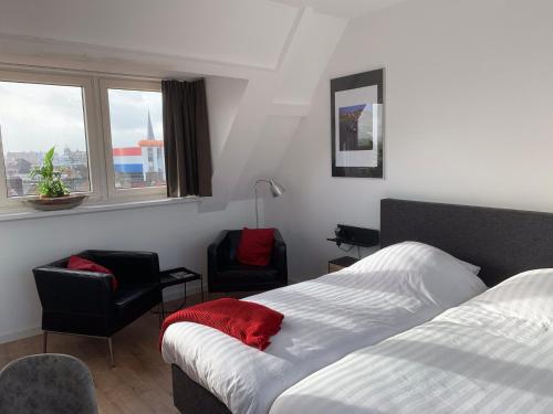 - une chambre avec un lit, deux chaises et une fenêtre dans l'établissement Bij Frits, à Zandvoort