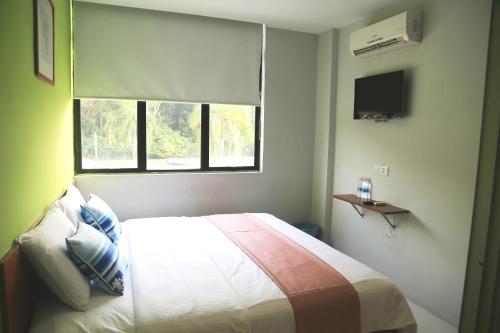a bedroom with a large bed with a window at WL HOTEL in Kampung Baharu Sungai Buluh
