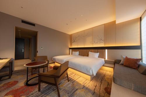 A bed or beds in a room at THE BLOSSOM HAKATA Premier