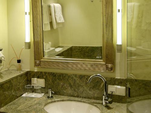 a bathroom with two sinks and a large mirror at Landhotel Zum Bären in Balduinstein