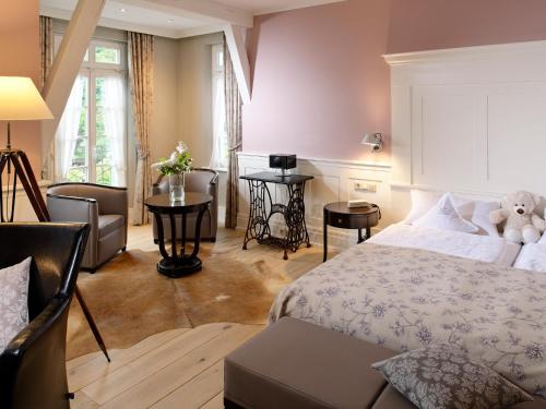 a bedroom with a bed with a teddy bear on it at Landhotel Zum Bären in Balduinstein