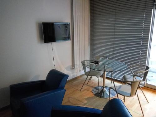 ein Wohnzimmer mit einem Glastisch und einem blauen Sofa in der Unterkunft Appartement 2 pieces 40 m2, dans hyper centre, avec piscine au rez de chaussee in Grenoble