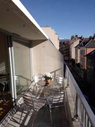 einen Balkon mit Stühlen und einem Tisch mit Blumen darauf in der Unterkunft Appartement 2 pieces 40 m2, dans hyper centre, avec piscine au rez de chaussee in Grenoble
