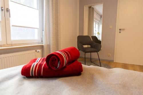 - un oreiller rouge assis au-dessus du lit dans l'établissement Fewo Lindenstrasse, à Großrudestedt