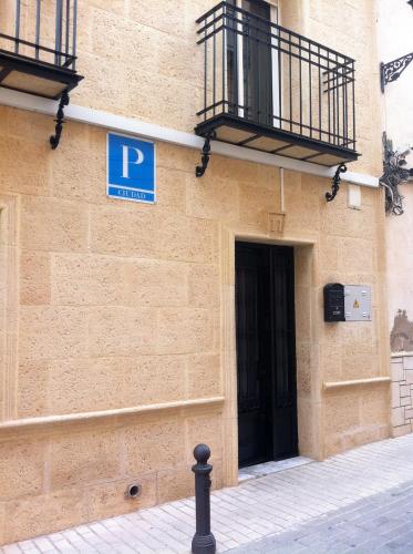un panneau de stationnement bleu sur le côté d'un bâtiment dans l'établissement Pensión Ruiz, à Linares