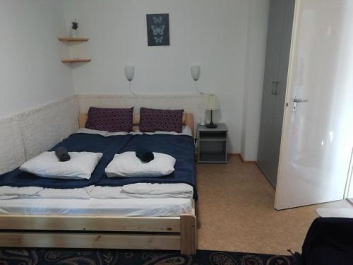 una camera da letto con un letto con due gatti sdraiati sopra di Azúr apartman a Harkány