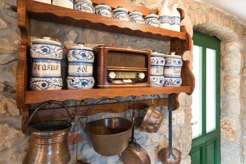 a shelf with blue and white ceramics and a microwave at Holiday Home Bozanić in Vrbnik