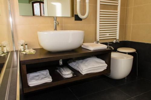 a bathroom with a sink and a toilet with towels at Hotel Sant'Antonin in Venice