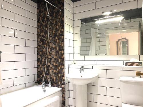 W łazience znajduje się umywalka, toaleta i lustro. w obiekcie The Birmingham Hotel w Birmingham