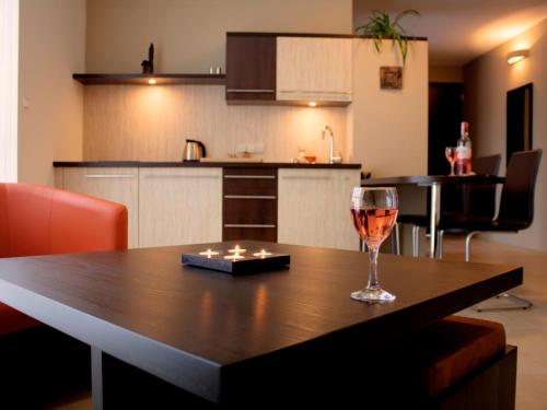 una copa de vino sentada en una mesa en una cocina en Puenta Aparthotel, en Krynica-Zdrój