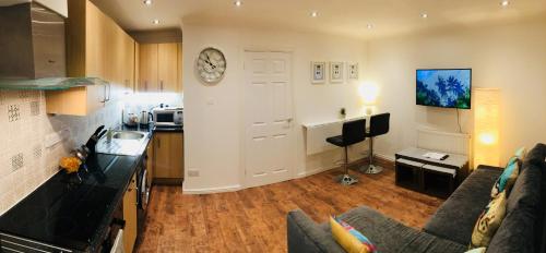 a kitchen and living room with a couch and a table at Fountain View 1BR Flat Oxford - Free Parking in Oxford