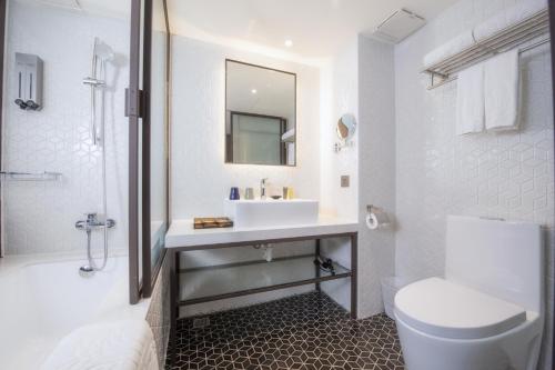City Suites - Main Station في تايبيه: حمام أبيض مع حوض ومرحاض