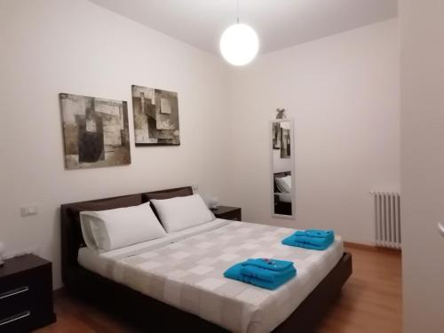 een slaapkamer met een bed met twee blauwe handdoeken erop bij Appartamento elegante nuovissimo in Quartu SantʼElena