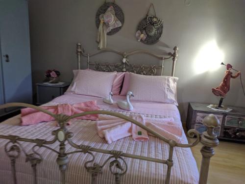 a bedroom with a bed with pink sheets and dolls on it at Petrameli in Karpenisi