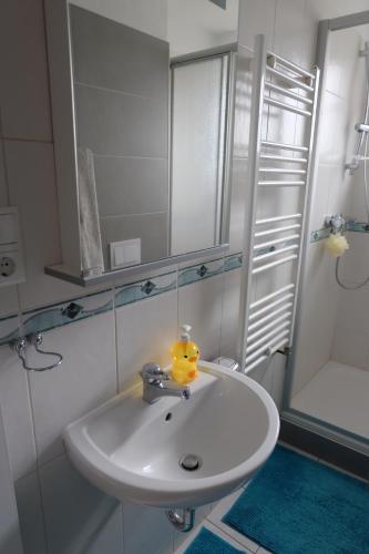 ein weißes Badezimmer mit einem Waschbecken und einem Spiegel in der Unterkunft Ferienhaus am Wald in Bad Elster